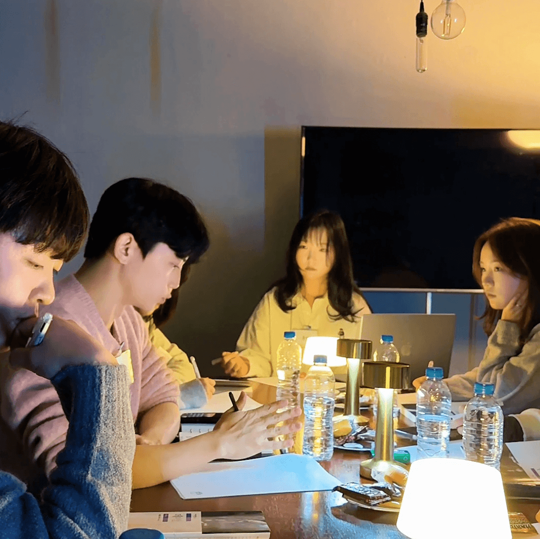 책과 노트를 앞에 두고 자신의 생각을 이야기하는 멤버들