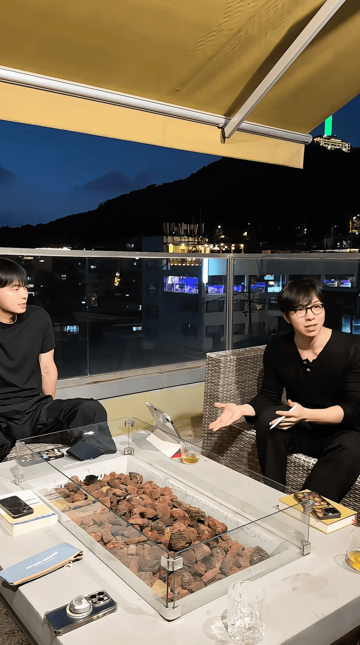 밤 테라스에서 책을 곁에 두고 이야기하는 두 사람
